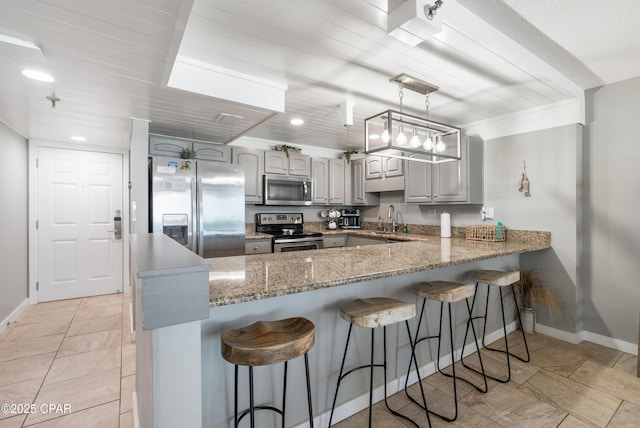 6201 Thomas Dr Unit 202, Panama City Beach, FL 32408 - kitchen featuring appliances with stainless steel finishes, a peninsula, baseboards, a sink, and recessed lighting