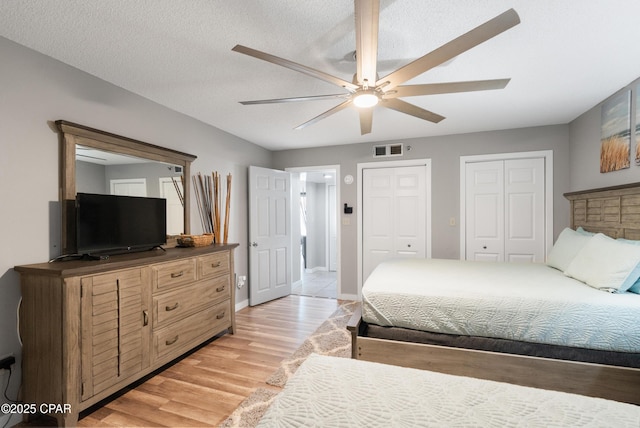 6201 Thomas Dr Unit 202, Panama City Beach, FL 32408 - bedroom featuring multiple closets, light wood finished floors, ceiling fan, and baseboards