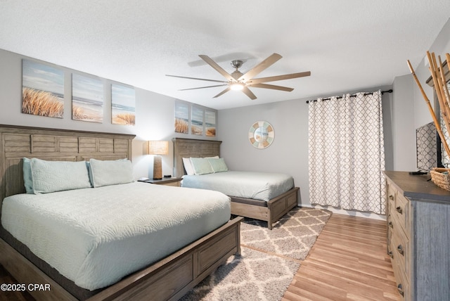 6201 Thomas Dr Unit 202, Panama City Beach, FL 32408 - bedroom with light wood-style floors, a ceiling fan, and baseboards