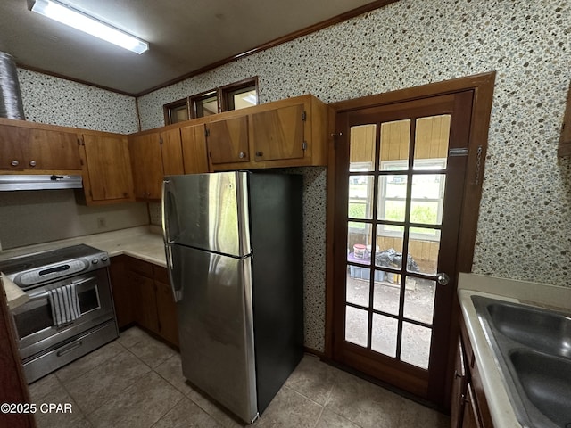 1006 N Church Ave, Panama City, FL 32401 - kitchen with appliances with stainless steel finishes, extractor fan, light tile patterned floors, light countertops, and wallpapered walls