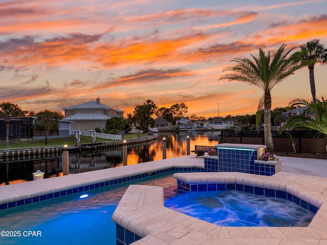 1507 Trout Ln, Panama City Beach, FL 32408 - pool at dusk featuring an in-ground hot tub, a water view, a boat dock, and boat lift