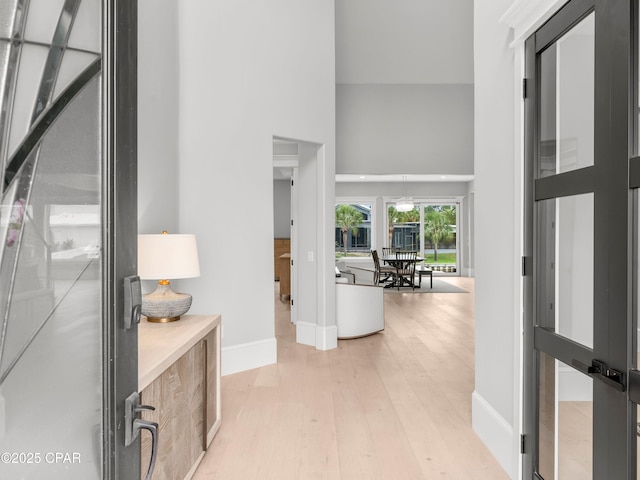 1507 Trout Ln, Panama City Beach, FL 32408 - corridor featuring a towering ceiling, light wood finished floors, and baseboards