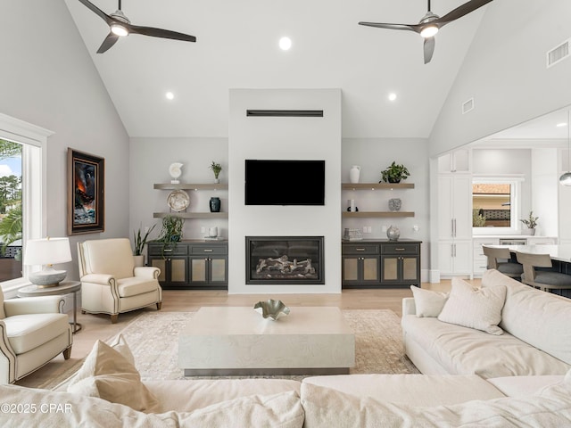 1507 Trout Ln, Panama City Beach, FL 32408 - living area featuring a ceiling fan, high vaulted ceiling, a glass covered fireplace, light wood-style floors, and recessed lighting