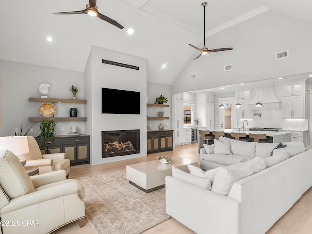 1507 Trout Ln, Panama City Beach, FL 32408 - living area with a ceiling fan, a glass covered fireplace, light wood-style floors, high vaulted ceiling, and recessed lighting
