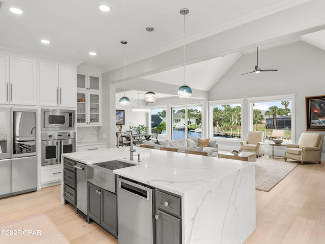 1507 Trout Ln, Panama City Beach, FL 32408 - kitchen featuring stainless steel appliances, a sink, open floor plan, white cabinets, and an island with sink