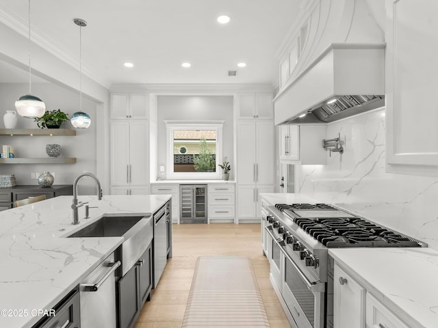 1507 Trout Ln, Panama City Beach, FL 32408 - kitchen featuring wine cooler, high end stainless steel range, premium range hood, a sink, and white cabinets