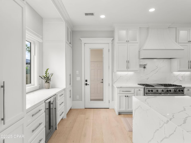 1507 Trout Ln, Panama City Beach, FL 32408 - kitchen with custom exhaust hood, beverage cooler, stainless steel gas range oven, white cabinets, and recessed lighting