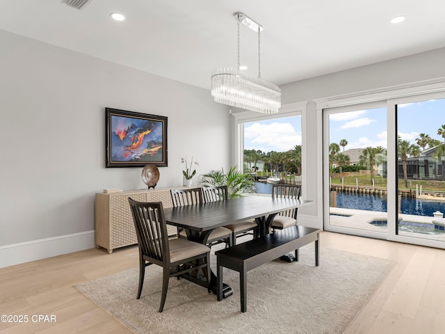 1507 Trout Ln, Panama City Beach, FL 32408 - dining space with light wood-style floors, recessed lighting, a chandelier, a water view, and baseboards