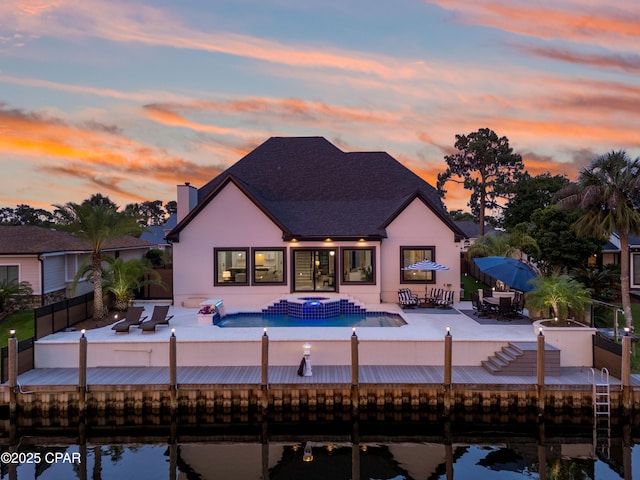1507 Trout Ln, Panama City Beach, FL 32408 - back of house featuring a patio area, a fenced backyard, a chimney, and a water view