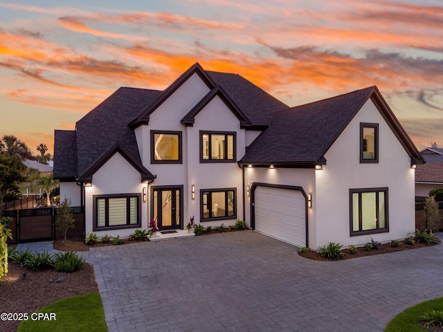 1507 Trout Ln, Panama City Beach, FL 32408 - french provincial home with decorative driveway, stucco siding, roof with shingles, and an attached garage