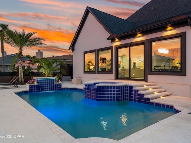 1507 Trout Ln, Panama City Beach, FL 32408 - pool at dusk featuring a pool with connected hot tub and a patio
