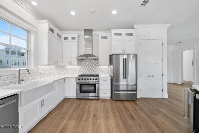 58 Hightide Way, Inlet Beach, FL 32413 - kitchen featuring appliances with stainless steel finishes, wall chimney exhaust hood, a sink, crown molding, and plenty of natural light