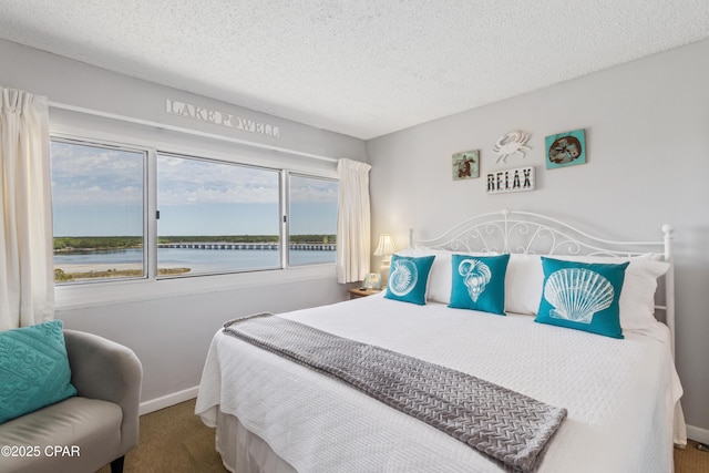 23223 Front Beach Rd Unit A704, Panama City Beach, FL 32413 - carpeted bedroom featuring a textured ceiling, a water view, and baseboards
