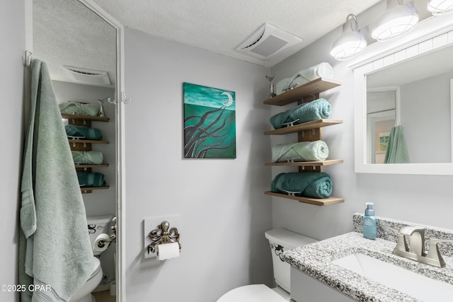 23223 Front Beach Rd Unit A704, Panama City Beach, FL 32413 - bathroom featuring toilet, vanity, and a textured ceiling