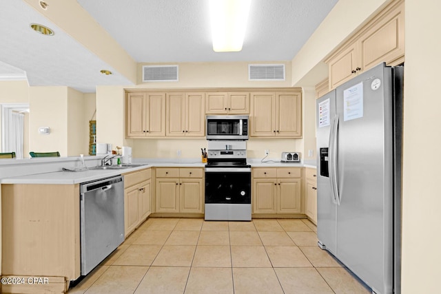 8715 Surf Dr Unit 304B, Panama City, FL 32408 - kitchen with stainless steel appliances, a peninsula, and light brown cabinetry