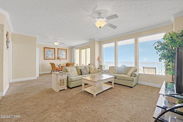 8715 Surf Dr Unit 304B, Panama City, FL 32408 - living room featuring a ceiling fan, light colored carpet, a textured ceiling, healthy amount of natural light, and crown molding