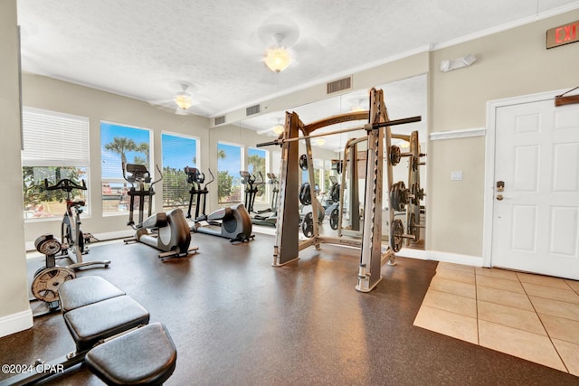 8715 Surf Dr Unit 304B, Panama City, FL 32408 - gym featuring a textured ceiling, a ceiling fan, and ornamental molding