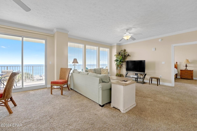 8715 Surf Dr Unit 304B, Panama City, FL 32408 - living area with a ceiling fan, light carpet, crown molding, a textured ceiling, and a water view