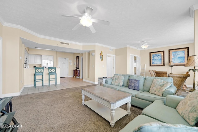 8715 Surf Dr Unit 304B, Panama City, FL 32408 - living area with ceiling fan, a textured ceiling, light tile patterned flooring, crown molding, and light colored carpet
