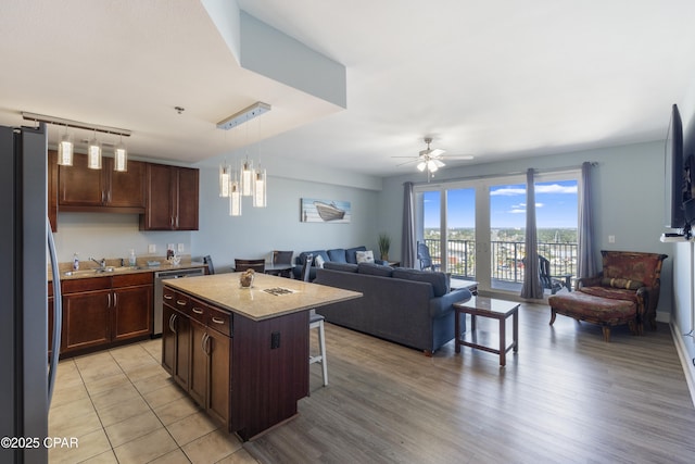 9902 Thomas Dr Unit 1735, Panama City Beach, FL 32407 - kitchen with open floor plan, appliances with stainless steel finishes, a ceiling fan, a sink, and a kitchen island