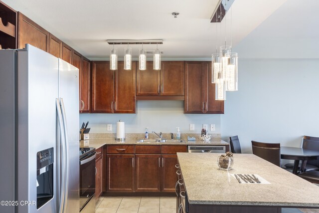 9902 Thomas Dr Unit 1735, Panama City Beach, FL 32407 - kitchen with stainless steel appliances, a sink, a center island, light tile patterned flooring, and light stone countertops
