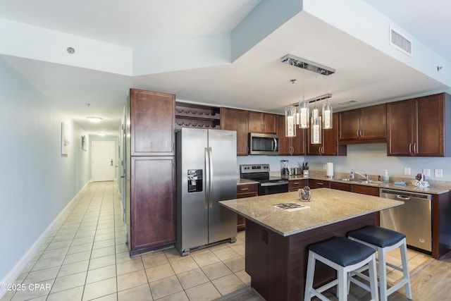 9902 Thomas Dr Unit 1735, Panama City Beach, FL 32407 - kitchen with appliances with stainless steel finishes, a sink, a kitchen bar, a center island, and open shelves
