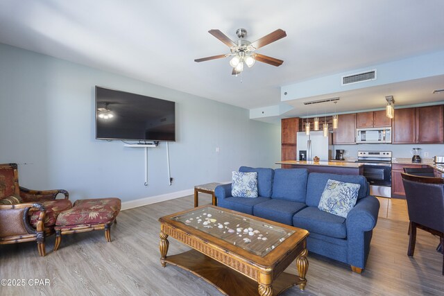 9902 Thomas Dr Unit 1735, Panama City Beach, FL 32407 - living room with light wood-style floors, a ceiling fan, and baseboards