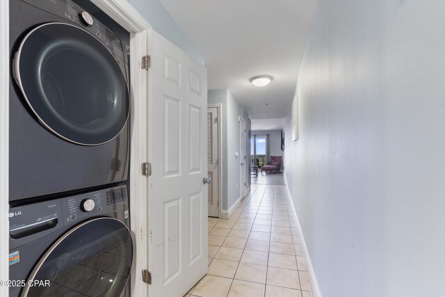 9902 Thomas Dr Unit 1735, Panama City Beach, FL 32407 - laundry room featuring stacked washer / drying machine, light tile patterned floors, and baseboards