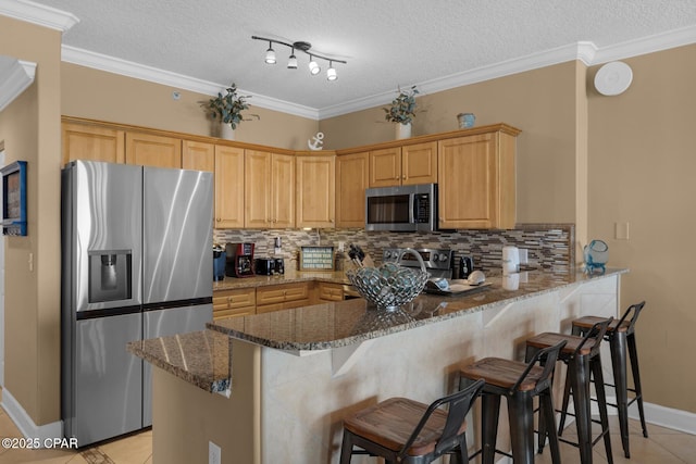 10519 Front Beach Rd Unit 601A, Panama City Beach, FL 32407 - kitchen with stainless steel appliances, decorative backsplash, light tile patterned floors, dark stone countertops, and a textured ceiling