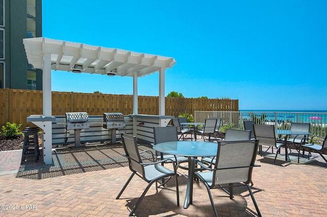 10519 Front Beach Rd Unit 601A, Panama City Beach, FL 32407 - view of patio featuring outdoor dining area, a pergola, a grill, and a water view