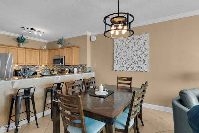 10519 Front Beach Rd Unit 601A, Panama City Beach, FL 32407 - dining area with light tile patterned flooring, a textured ceiling, ornamental molding, a chandelier, and baseboards