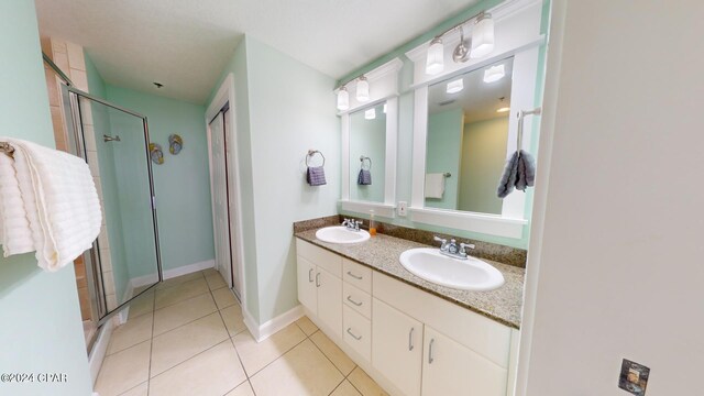 11800 Front Beach Rd Unit 2-201, Panama City Beach, FL 32407 - bathroom featuring double vanity, tile patterned floors, a shower stall, and baseboards