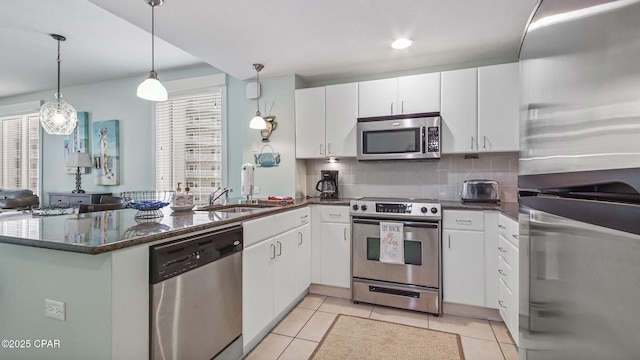 11800 Front Beach Rd Unit 2-201, Panama City Beach, FL 32407 - kitchen with appliances with stainless steel finishes, a peninsula, white cabinets, and decorative backsplash