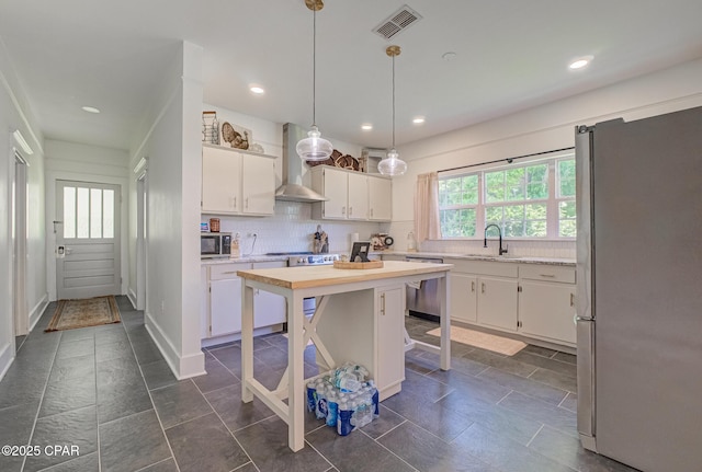 5138 8th Ave, Malone, FL 32445 - kitchen featuring stainless steel appliances, wall chimney exhaust hood, a sink, white cabinetry, and tasteful backsplash