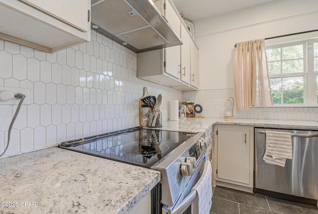 5138 8th Ave, Malone, FL 32445 - kitchen with appliances with stainless steel finishes, ventilation hood, backsplash, dark tile patterned floors, and light stone counters