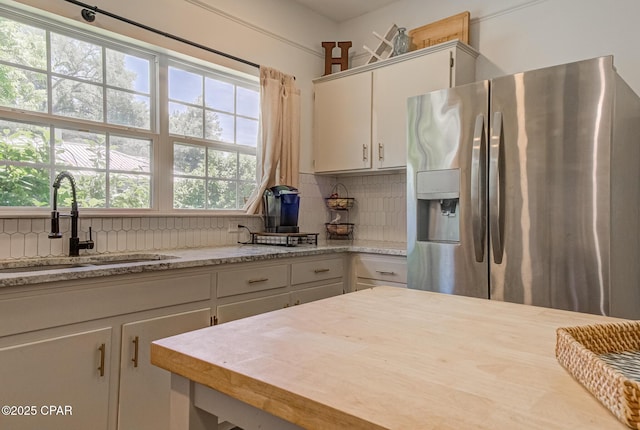 5138 8th Ave, Malone, FL 32445 - kitchen with stainless steel refrigerator with ice dispenser, a sink, decorative backsplash, and white cabinetry