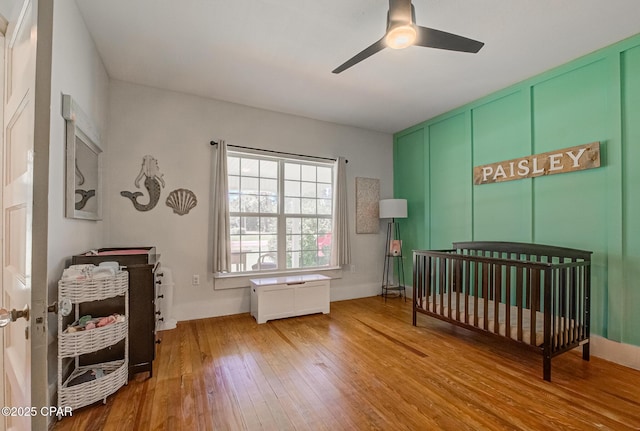 5138 8th Ave, Malone, FL 32445 - bedroom with hardwood / wood-style floors, a crib, and a ceiling fan