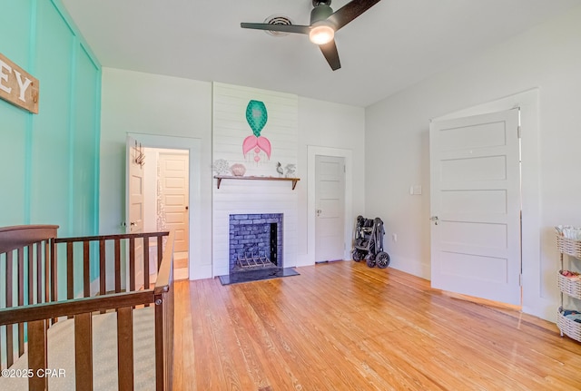 5138 8th Ave, Malone, FL 32445 - living area with ceiling fan, light wood-style floors, and a fireplace
