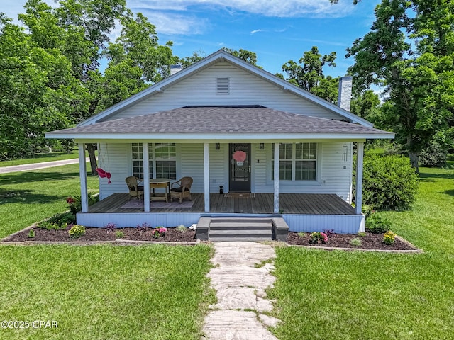 5138 8th Ave, Malone, FL 32445 - view of front of house featuring roof with shingles, a chimney, a porch, and a front lawn