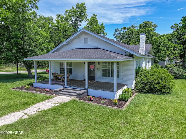 5138 8th Ave, Malone, FL 32445 - view of front of house with a shingled roof, a chimney, a front lawn, and covered porch