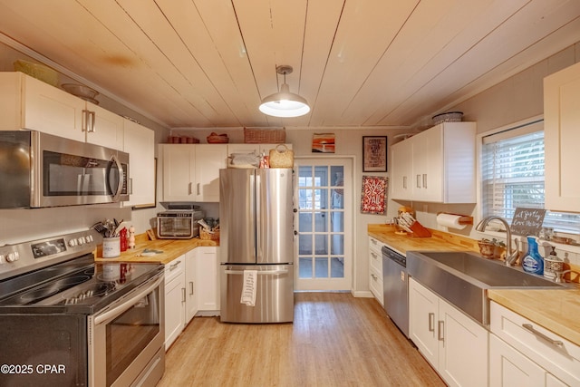 5821 S Lagoon Dr, Panama City, FL 32408 - kitchen with stainless steel appliances, light wood-type flooring, white cabinetry, crown molding, and a sink