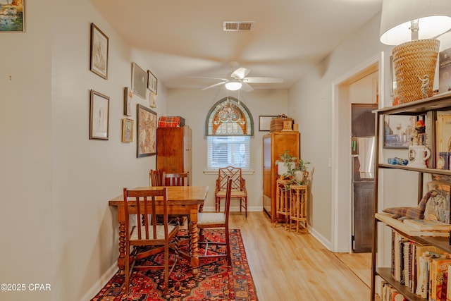 5821 S Lagoon Dr, Panama City, FL 32408 - dining space with light wood-type flooring, ceiling fan, and baseboards
