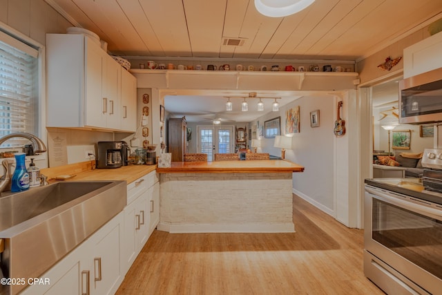 5821 S Lagoon Dr, Panama City, FL 32408 - kitchen with appliances with stainless steel finishes, a sink, white cabinets, light wood-style floors, and wooden ceiling