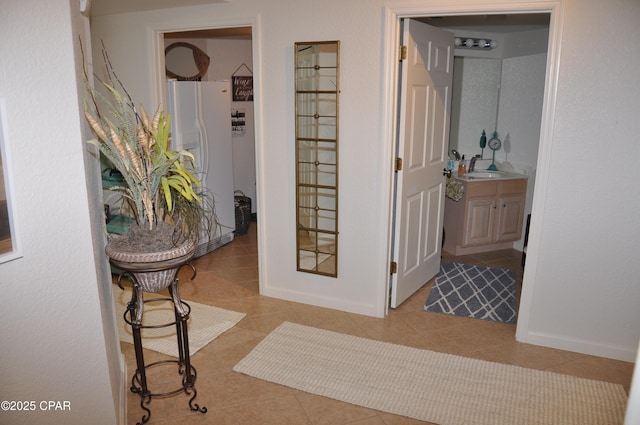 6504 Bridge Water Way Unit 606, Panama City Beach, FL 32407 - hallway with light tile patterned flooring, baseboards, and a sink