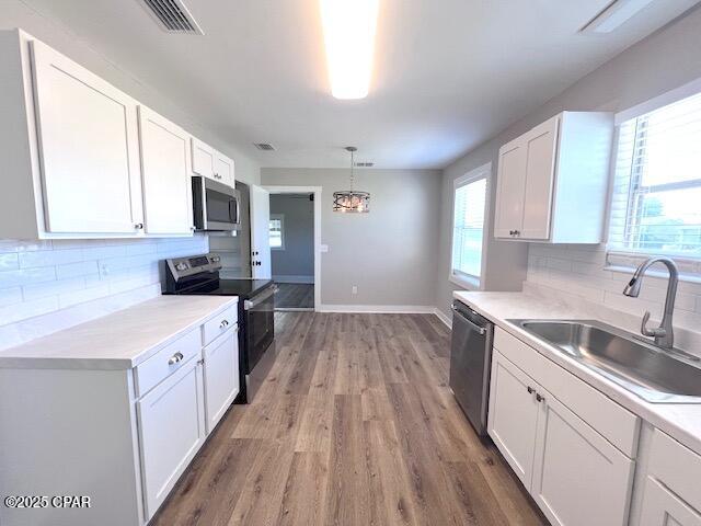 703 Amy St, Lynn Haven, FL 32444 - kitchen with stainless steel appliances, a sink, white cabinetry, and backsplash