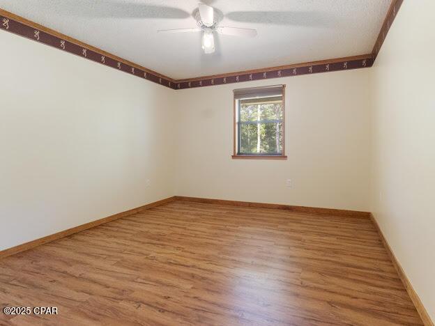 2921 Ambus Ln, Chipley, FL 32428 - spare room with ceiling fan, wood finished floors, and baseboards