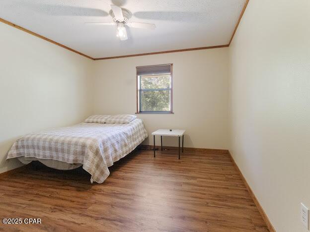 2921 Ambus Ln, Chipley, FL 32428 - bedroom with ornamental molding, wood finished floors, a ceiling fan, and baseboards