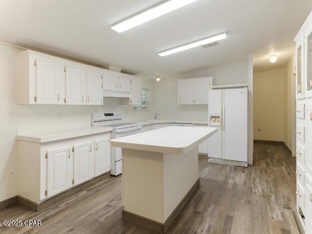2921 Ambus Ln, Chipley, FL 32428 - kitchen featuring white appliances, dark wood-type flooring, under cabinet range hood, light countertops, and white cabinetry