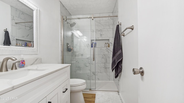 612 Laurel St Unit D, Panama City Beach, FL 32407 - bathroom with vanity, toilet, a marble finish shower, wood finished floors, and a textured ceiling