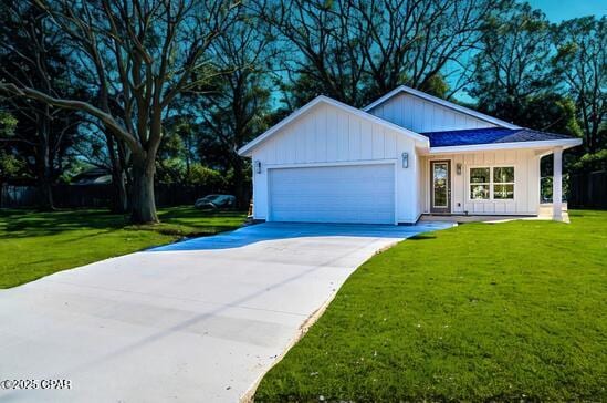 2002 Norwood Pl, Panama City, FL 32405 - view of front of home featuring board and batten siding, a garage, driveway, and a front yard